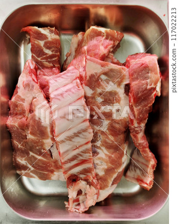 Raw pork ribs placed in a stainless steel compartment sold in supermarkets 117022213