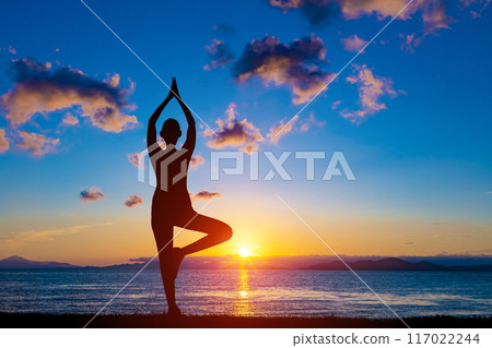 A woman who plays a yoga pose 117022244