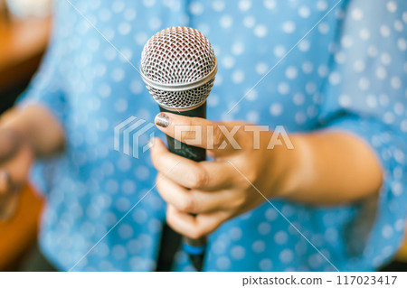 Close up hand holding a microphone Close up hand holding a microphone 117023417