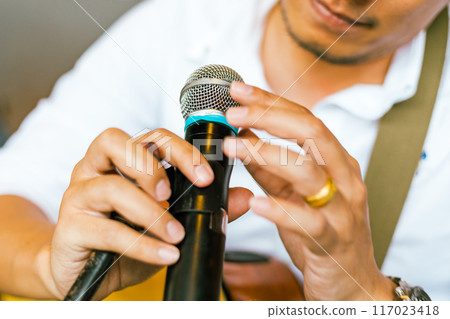 Close up hand holding a microphone 117023418