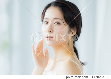 一位年輕女子感到皮膚濕潤 一位年輕女子感到皮膚濕潤 117023453