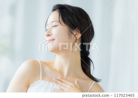 一位年輕女子感到皮膚濕潤 一位年輕女子感到皮膚濕潤 117023465