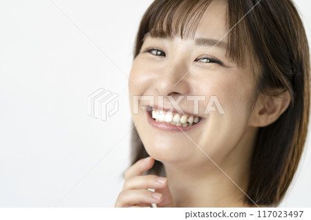 A woman in her 30s with a beautiful smile and straight teeth, looking at the camera, portrait A woman in her 30s with a beautiful smile and straight teeth, looking at the camera, portrait 117023497