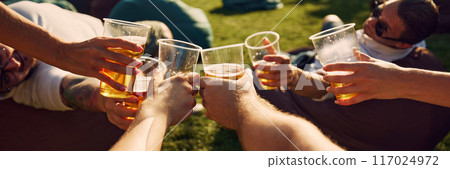Human hands people gathering outdoors, clinking beer glasses, celebrating weekends, attending picnic and festivals 117024972