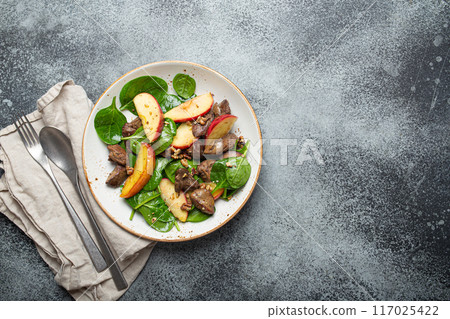 Healthy Salad with Iron Rich Ingredients Chicken Liver, Apples, Fresh Spinach and Walnuts on White Ceramic Plate, Grey Rustic Stone Background From Above. 117025422
