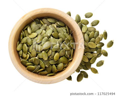 Pumpkin seeds in a wooden plate cut out on a white. Top view 117025494