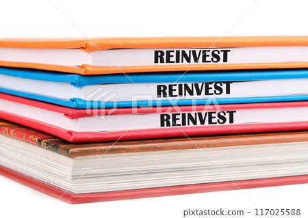 Business and reinvest concept. Copy space. REINVEST word on the ends of notebooks lying on top of each other on a white background Business and reinvest concept. Copy space. REINVEST word on the ends of notebooks lying on top of each other on a white background 117025588