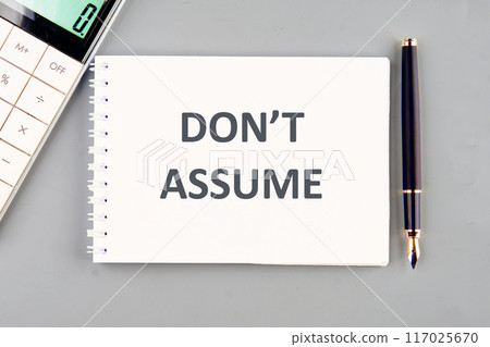The words Don't Assume in a notebook on a gray background The words Don't Assume in a notebook on a gray background 117025670