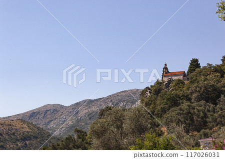 Mountain landscape with blue sky and trees. A church stands on top of the mountain. View from above. Horizontal Mountain landscape with blue sky and trees. A church stands on top of the mountain. View from above. Horizontal 117026031