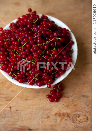 Currants in a bowl on a wooden background. Red berry. Vitamin berries. Copy space 117026610