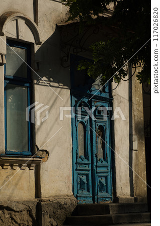 blue old wooden door in an old house on a sunny day blue old wooden door in an old house on a sunny day 117026820