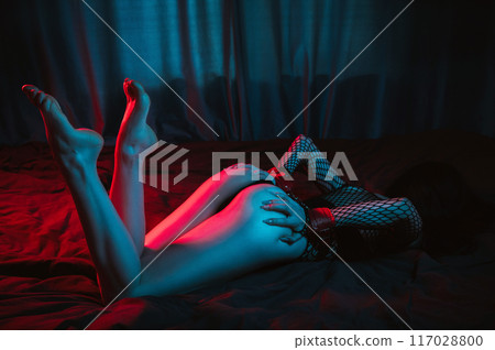 submissive woman with sexy body and ass with hands in BDSM handcuffs lies on bed in bedroom. Slave girl in lingerie for sex with submission and domination submissive woman with sexy body and ass with hands in BDSM handcuffs lies on bed in bedroom. Slave girl in lingerie for sex with submission and domination 117028800