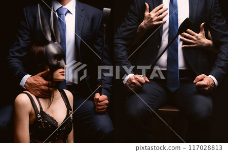 BDSM couple sex. Dominant men boss in a suit with a flogger whip dominates a submissive slave woman bottom girl in mask BDSM couple sex. Dominant men boss in a suit with a flogger whip dominates a submissive slave woman bottom girl in mask 117028813