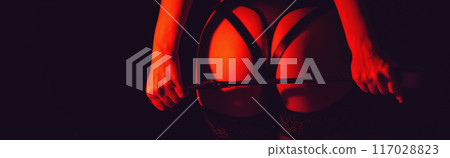 woman dominant mistress girl with a sexy ass in panties holding a leather whip flogger in female hands. BDSM sex with submission and domination. Wide banner with a black background woman dominant mistress girl with a sexy ass in panties holding a leather whip flogger in female hands. BDSM sex with submission and domination. Wide banner with a black background 117028823