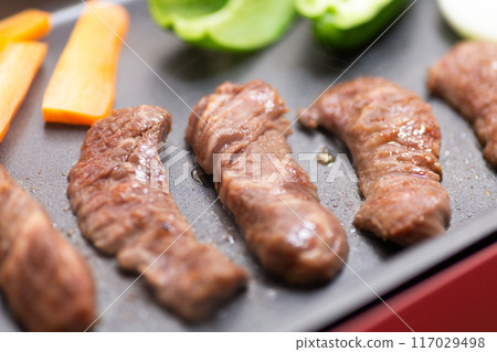 Grilling meat on a hot plate (beef loin) 117029498