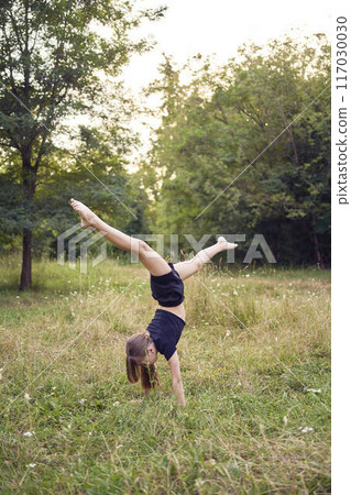 A 10-year-old gymnast practices in the garden 117030030