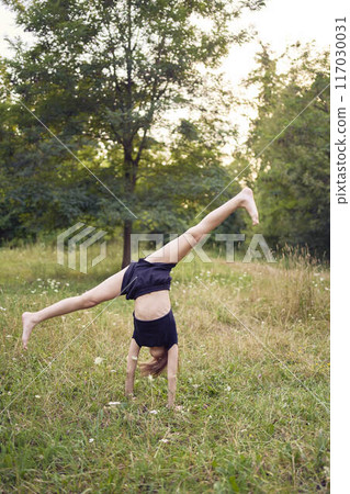 A 10-year-old gymnast practices in the garden A 10-year-old gymnast practices in the garden 117030031