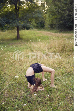 A 10-year-old gymnast practices in the garden 117030035