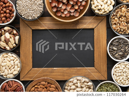 Peanut,hazelnut,walnut,almonds,pistachio,sunflower,pumpkin,chia,pecan and cashew mixed healthy nuts and seeds with menu board.Top view. Peanut,hazelnut,walnut,almonds,pistachio,sunflower,pumpkin,chia,pecan and cashew mixed healthy nuts and seeds with menu board.Top view. 117030264