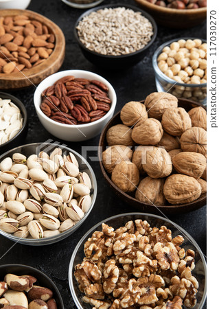 Raw walnuts and cashew with almonds and peanuts with organic nuts and seed in various bowls. Raw walnuts and cashew with almonds and peanuts with organic nuts and seed in various bowls. 117030270