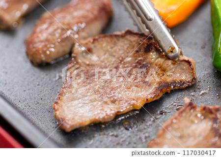 Grilling yakiniku (beef skirt steak) on a hot plate Grilling yakiniku (beef skirt steak) on a hot plate 117030417