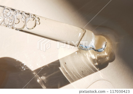 Pipette with serum on a beige background. Pipette with serum on a beige background. 117030423