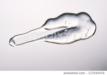 A smear of cosmetic gel close-up on a gray background. Appetizing texture with bubbles. A smear of cosmetic gel close-up on a gray background. Appetizing texture with bubbles. 117030438