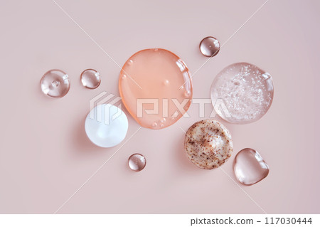 Several cosmetic products on a pink background.  117030444
