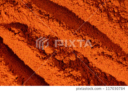 Abstract terracotta striped background of scattered paprika seasoning Abstract terracotta striped background of scattered paprika seasoning 117030784