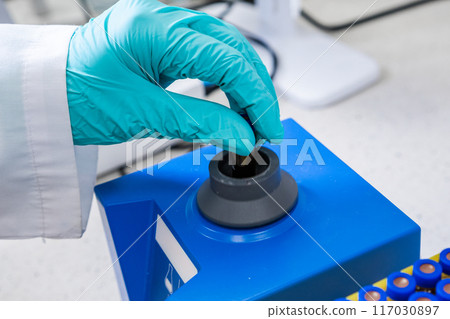 Prior to HPLC analysis, a chemist shakes samples using a vortex mixer Prior to HPLC analysis, a chemist shakes samples using a vortex mixer 117030897