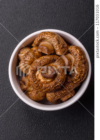 Delicious juicy whole champignons baked on the grill with salt and spices 117031016