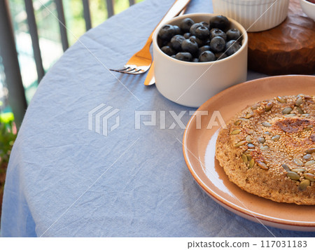Table with blue napkin with served breakfast outdoors Table with blue napkin with served breakfast outdoors 117031183