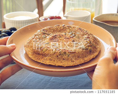 Female hands holding dish with homemade protein bread Female hands holding dish with homemade protein bread 117031185