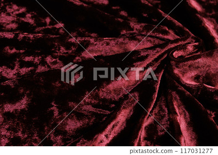 Textured background of deep red velour fabric with folds. 117031277