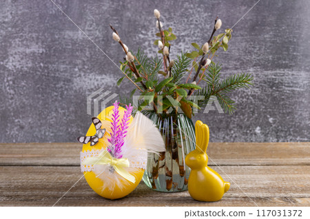 Wooden table with Easter bunny, egg and bunch of willow. Wooden table with Easter bunny, egg and bunch of willow. 117031372