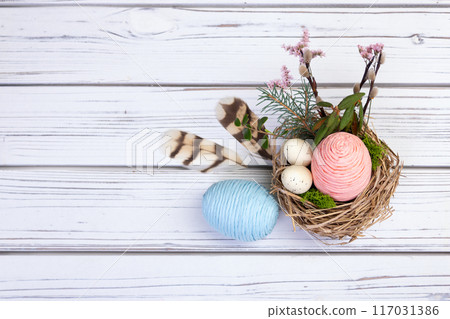 Easter decoration nest with eggs, flowers, branches and feathers. 117031386