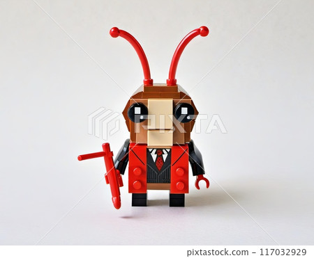 A lego cockroach or an ant in a suit and tie stands on a yellow base 117032929