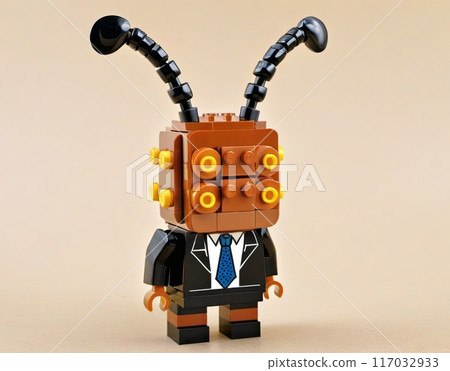 A lego cockroach or an ant in a suit and tie stands on a yellow base 117032933