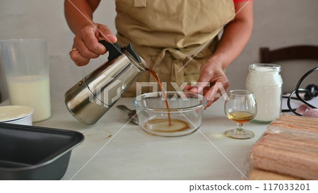 Housewife woman chef in kitchen apron cooking, preparing Italian meal in the home kitchen Housewife woman chef in kitchen apron cooking, preparing Italian meal in the home kitchen 117033201