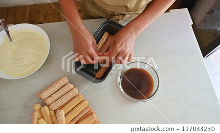 Housewife woman chef in kitchen apron cooking, preparing Italian meal in the home kitchen Housewife woman chef in kitchen apron cooking, preparing Italian meal in the home kitchen 117033230