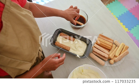 Housewife woman chef in kitchen apron cooking, preparing Italian meal in the home kitchen Housewife woman chef in kitchen apron cooking, preparing Italian meal in the home kitchen 117033235