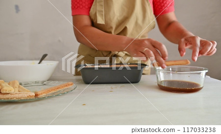 Housewife woman chef in kitchen apron cooking, preparing Italian meal in the home kitchen Housewife woman chef in kitchen apron cooking, preparing Italian meal in the home kitchen 117033238