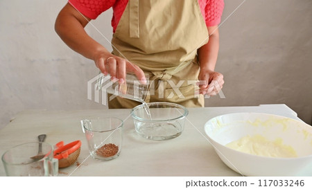 Housewife woman chef in kitchen apron cooking, preparing Italian meal in the home kitchen Housewife woman chef in kitchen apron cooking, preparing Italian meal in the home kitchen 117033246