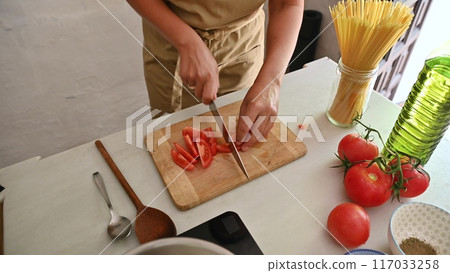 Housewife woman chef in kitchen apron cooking, preparing Italian meal in the home kitchen 117033258