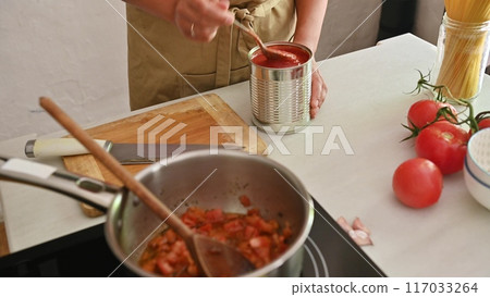 Housewife woman chef in kitchen apron cooking, preparing Italian meal in the home kitchen 117033264