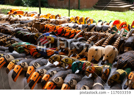 A vibrant collection of handcrafted wooden animal figures displayed at a market 117033359