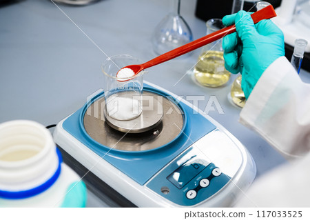 Close up of a woman weighing powder samples using laboratory balances 117033525