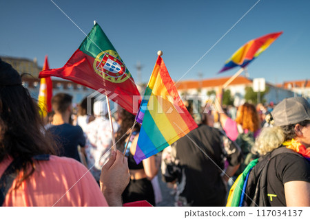 LGBTQ person holding flags of Portugal and rainbow LGBTQ person holding flags of Portugal and rainbow 117034137