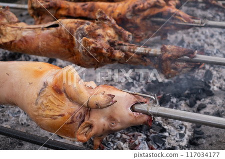 A pig grilled traditional coal and fire.  117034177