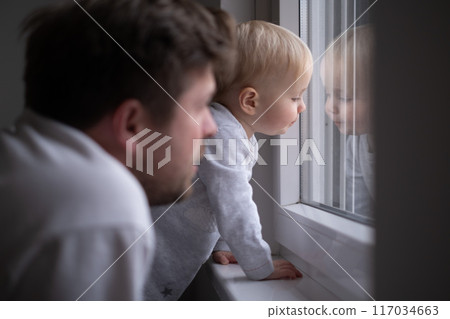Father with toddler girl daughter looking into window  117034663
